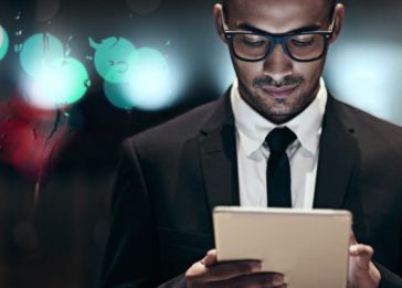 homem negro com perfil executivo interagindo com um ipad