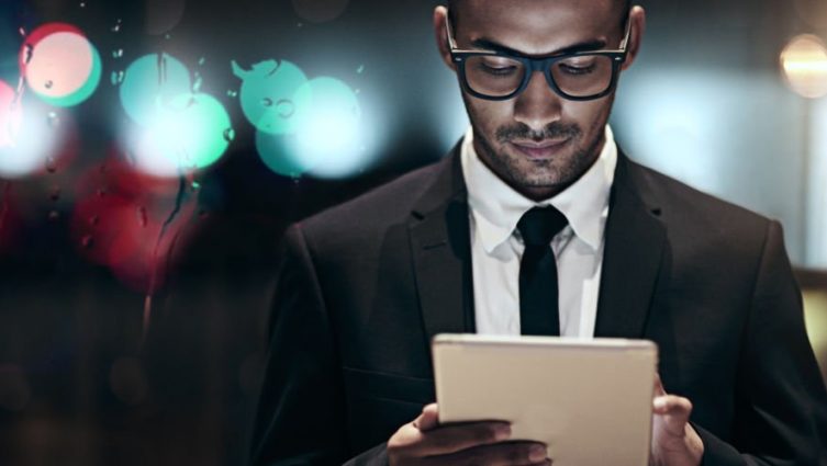 homem negro com perfil executivo interagindo com um ipad
