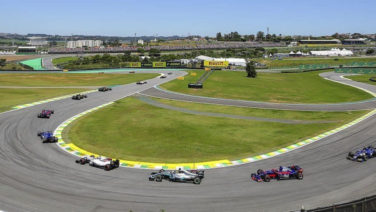 Carros de fórmula 1 correndo na pista de um autódromo