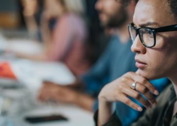 Programadora africana observa computador com muitos dados