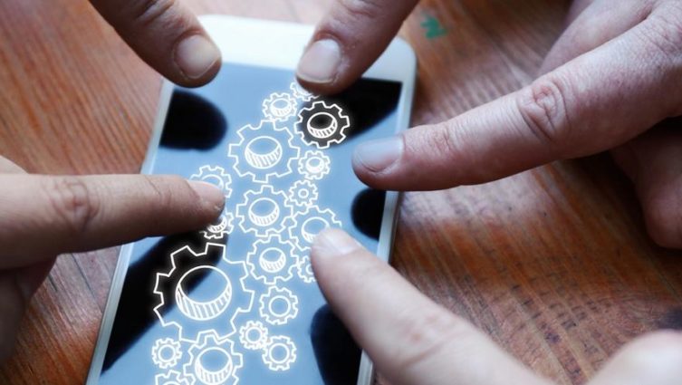 Pessoas apontando o dedo para a tela de um smartphone para exemplificar a transformação digital