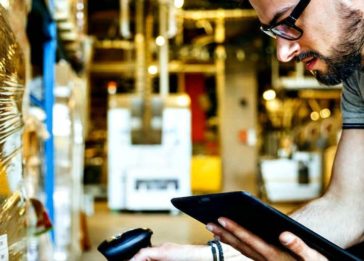 Homem com tablet e leitor RFID é um exemplo do impacto da IoT e do 5G na logística