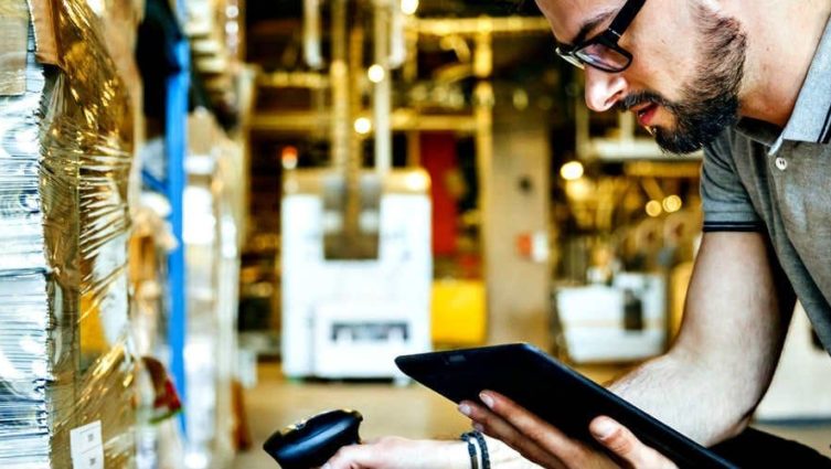 Homem com tablet e leitor RFID é um exemplo do impacto da IoT e do 5G na logística