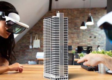 Jovem com óculos de realidade virtual observa a maquete de um edifício