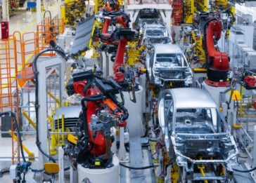 Linha de produção automotiva com robôs auxiliando na produção de veículos