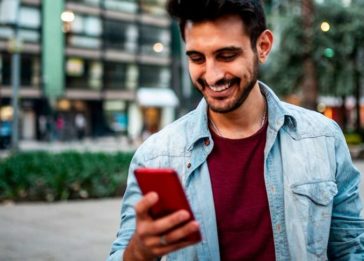 Homem olha para um telefone celular em uma interação de consumo