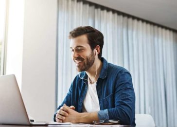 Homem olhando para a tela de um computador durante trabalho home office