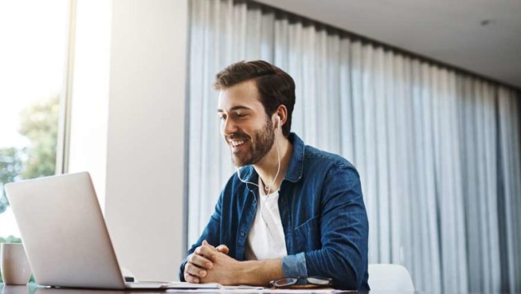 Homem olhando para a tela de um computador durante trabalho home office