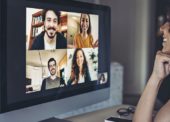 Mulher em frente ao computador conversa com amigos em uma video chamada