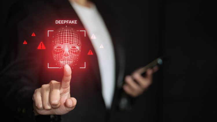 Painel digital com aviso de Deepfake e interface de reconhecimento, enquanto uma pessoa aponta para a tela, simbolizando o colapso da confiança digital